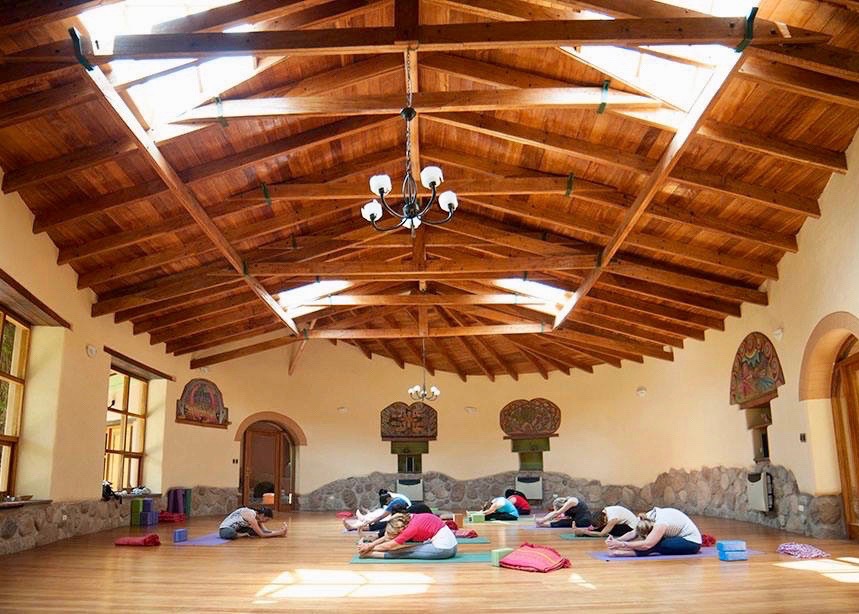 Sesión de yoga en grupo en centro de bienestar en Perú para viajeros en solitario.
